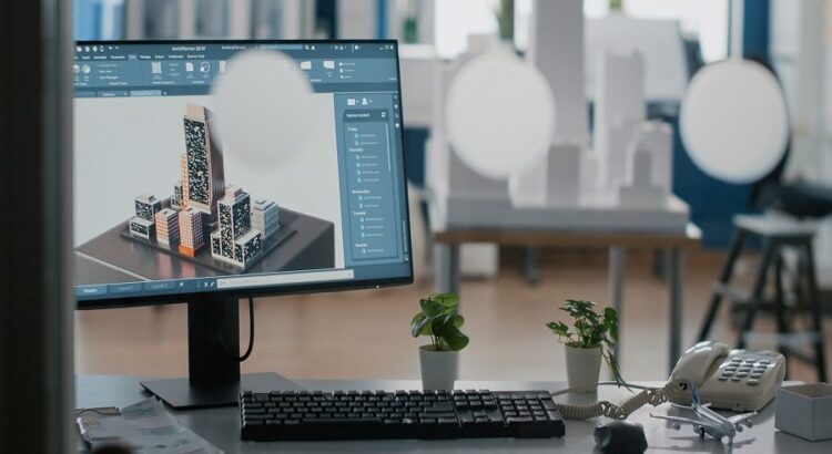 Close up of monitor with 3d building and construction layout on table in office.