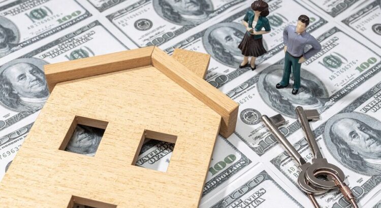 Investing in a house concept. Real estate prices. Toy house and figurine couple on dollar banknote background